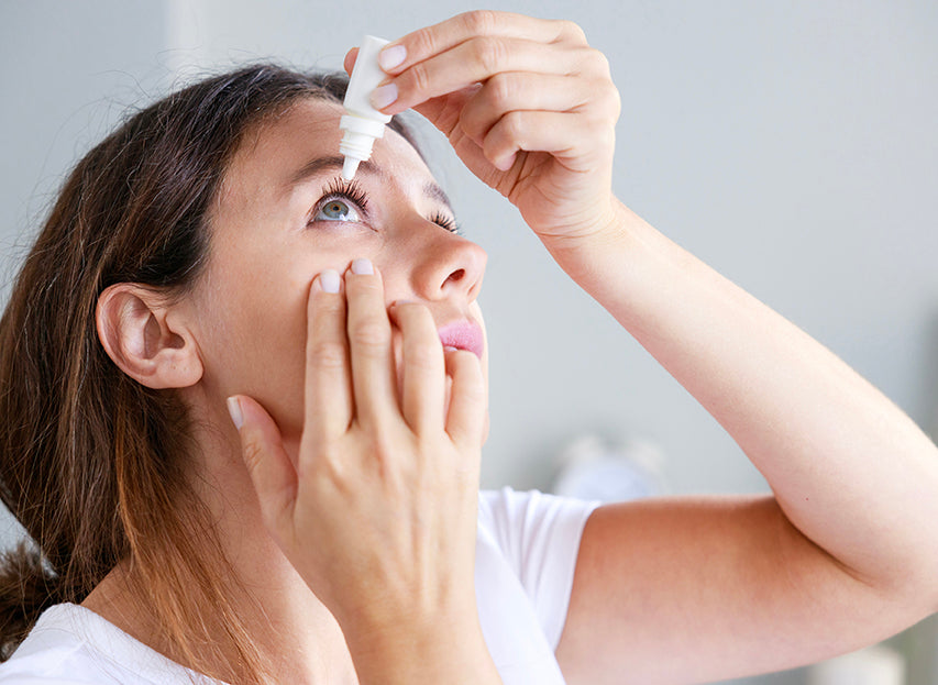 person putting eye drops in eye to relieve dry eye issues